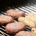 Hamburgers, chicken and hotdogs on a grill. 