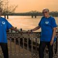 Two older women wearing blue MHV t-shirts sitting at a table overspread with papers.