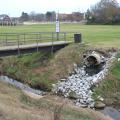 A drainage pipe, with stones leading to the creek bed, emptying into Catalpa Creek. 