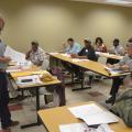 A Mississippi State University specialist stands before a room of seated meeting participants.