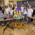 A group of people surround more than 20 musical instruments.