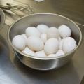 Several eggs sit in a bowl on a kitchen counter.