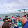 Mississippi State University Extension marine fisheries specialist Marcus Drymon shows a trawl-caught cutlassfish to fishermen during a 2022 field excursion. (Photo by MSU Extension/Marine Fisheries Ecology)