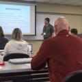 A man lectures from the front of a classroom.