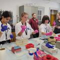 A group of young people use lab equipment in a classroom.