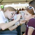 4-H, the youth development arm of the Mississippi State University Extension Service, took part in MSU’s Homecoming celebration Oct. 20. 4-H’er Sara Burns of Lauderdale County paints the face of Rachel Singleton of Leflore County at a pregame tailgate party.  (Photo by MSU Ag Communications/Kat Lawrence)