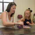 A parent's involvement can make any activity a learning experience. Jaden Claire Everett, 5, fashions a dog out of beads as her mother, Jana Carolyn Everett, assists. (Photo by MSU Ag Communications/Kevin Hudson)