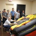 Dave Burrage, Mississippi State University Extension Service professor, demonstrates safety features on a life raft used aboard commercial fishing vessels. (Photo by MS-AL Sea Grant Consortium/Melissa Schneider)