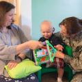 Heather Bond (left) plays with Thaddeus Pyko, while his mother, Maj. Kyla Pyko, watches. Bond is a family-home care provider who has opened her home to military families needing child care.  (Photo by MSU Extension Service/Alexandra Woolbright)