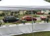 From inside a tent, cars can be seen lined up on the street.