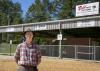 A man stands outside a structure.