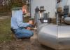 A man adjusts a valve on a water pipe.