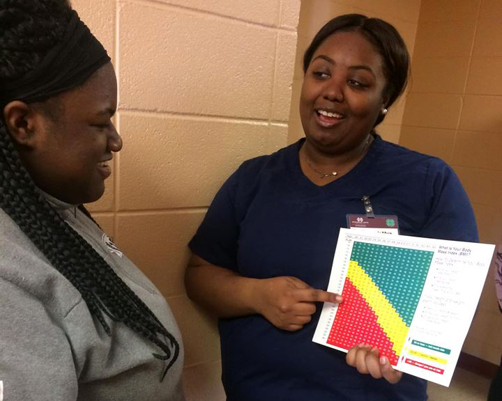 A JMWV explains the body mass index chart to a fellow classmate.